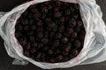 Blackberries in plastic bag on black background