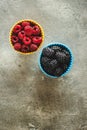 Blackberries and Raspberries in Ceramic Bowls on Rustic Stone Background Royalty Free Stock Photo
