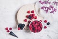 Blackberries and raspberries, waffle ice cream cone and flowers on white marble background Royalty Free Stock Photo