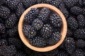 Blackberries in a wooden plate close-up, background. top view Royalty Free Stock Photo