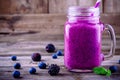 Blackberry and blueberry smoothie in a mason jar on a wooden background