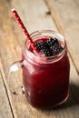 Blackberry cocktail with crushed ice in glass jar on the rustic wooden background. Selective focus. Shallow depth of field Royalty Free Stock Photo