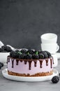 Blackberry cream mousse cake no baked cheesecake with chocolate glaze on a white plate on a dark background. Royalty Free Stock Photo