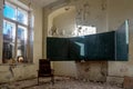 A blackboard in an abandoned school. An old abandoned school. Shabby walls. Armchair in the room.