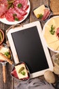 Blackboard with cheese raclette, salami, potato