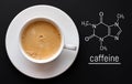 Blackboard with the chemical formula of caffeine, close up cup of fresh coffee on black background. Top view with copy space Royalty Free Stock Photo