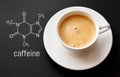 Blackboard with the chemical formula of caffeine, close up cup of fresh coffee on black background. Top view with copy space Royalty Free Stock Photo