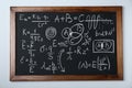 Blackboard with different physical formulas written with chalk on white wall Royalty Free Stock Photo