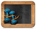 Blackboard with dumbbells and a tape measure Royalty Free Stock Photo