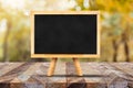 Blackboard with easel on old rustic wood plank table top with bl Royalty Free Stock Photo