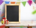 Blackboard with gift box and colorful flag banner on marble table at white wall,Leave space for display or montage of your design Royalty Free Stock Photo