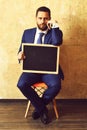 Blackboard in hands of teacher man or businessman in suit