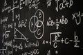 Blackboard inscribed with scientific formulas and calculations in physics, mathematics and electrical circuits. Science and Royalty Free Stock Photo