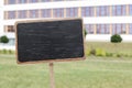 Blackboard label and a a primary school building in the background, Royalty Free Stock Photo
