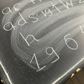 Blackboard with letters and numbers written in chalk. The letters include lowercase Royalty Free Stock Photo
