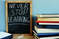 Blackboard with Never stop learning and books.