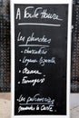 Blackboard outside restaurant in Lille, France, offers a variety of platters and pastries