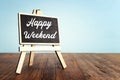 blackboard over wooden shelf with the phrase happy weekend Royalty Free Stock Photo