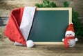 Blackboard With Red Santa Hat And Christmas snowman toy on old w Royalty Free Stock Photo