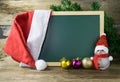 Blackboard With Red Santa Hat And Christmas snowman toy on old w Royalty Free Stock Photo