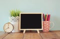 Blackboard, stack of colorful pencils and clock. back to school concept
