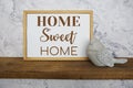 Blackboard with the text home sweet home decorate with bird statue on wooden shelf Royalty Free Stock Photo