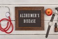 blackboard with text & x22;Alzheimer& x27;s disease& x22;, watch and stethoscope Royalty Free Stock Photo