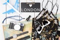 blackboard with text & x22;LOVE LONDON& x22;, plane, map, sunglasses, watch, camera