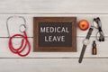 blackboard with text & x22;Medical leave& x22;, eyeglasses, watch and stethoscope Royalty Free Stock Photo