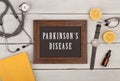 blackboard with text & x22;Parkinson& x27;s disease& x22;, book, stethoscope and watch