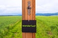 Blackboard with word Wanderlust in front of green field Royalty Free Stock Photo