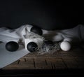 BlackEaster. Easter night. Black and White eggs, feathers on a wooden table. Vintage. Dark background Royalty Free Stock Photo