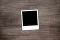 Blackened instant photo print template on wooden background Royalty Free Stock Photo