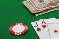 Blackjack hand with Dollar notes and chip on green