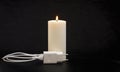 Blackout concept. Electric charger with cable near lighting candle on dark background Royalty Free Stock Photo