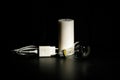 Blackout concept. Electric charger with cable near lighting candle on dark background Royalty Free Stock Photo