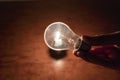 Power outage concept. Light bulb in hand by the light of a burning candle Royalty Free Stock Photo