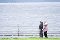 Blackpool, England / UK - July 6th 2019: Senior old couple walking at sea coast path