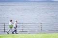 Blackpool, England / UK - July 6th 2019: Senior old couple walking at sea coast path