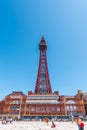 BLACKPOOL, UK, JUNE 30 2019: Tourists gather and relax in front of Blackpool Tower on the Comedy Carpet as an electric tram passes Royalty Free Stock Photo