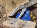 Blacksmith arms forge horseshoe with hammer on anvil