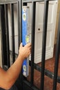 Blacksmith checking with level tool the correct placement of a metal entrance door