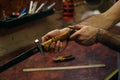 Blacksmith checks sharpening of blade of sword