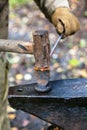 Blacksmith chops rod with sledgehammer and chisel Royalty Free Stock Photo