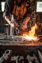 A blacksmith creating metalwork with traditional tools