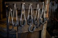 Blacksmith decorative horseshoes elements hanging at forge, workshop. Handmade, craftsmanship and blacksmithing Royalty Free Stock Photo