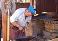 A Blacksmith Dressed in Traditional Outfit Forges Red Hot Metal into Swords