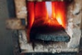 Blacksmith forge oven with hot flame. Smith heating iron piece of steel in fire of red-hot forge Royalty Free Stock Photo