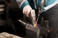 Blacksmith forges hinge on a anvil. Hammering hot red steel Royalty Free Stock Photo