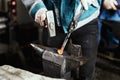 Blacksmith forges hinge on a anvil. Hammering hot red steel Royalty Free Stock Photo